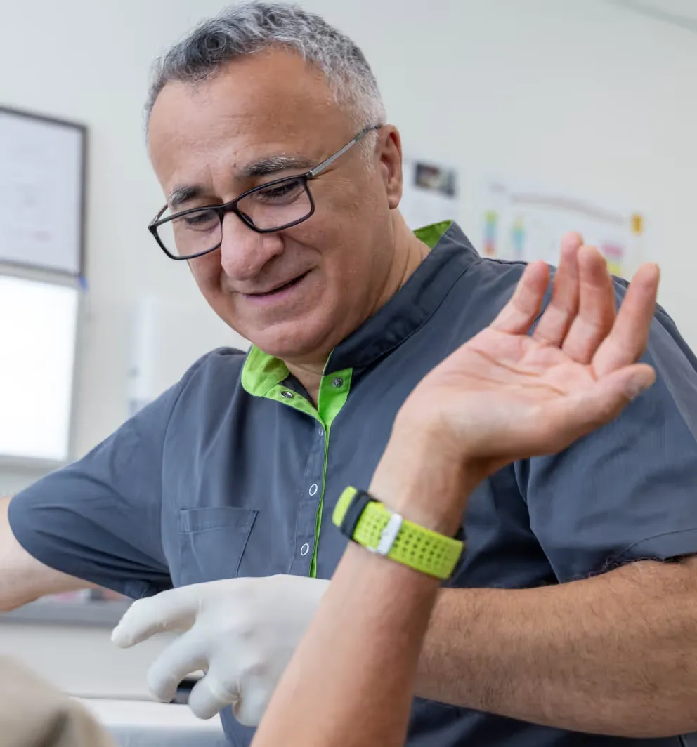 Dr. Ramin Ilbeygui, Facharzt für Orthopädie, untersucht den Arm eines Patienten